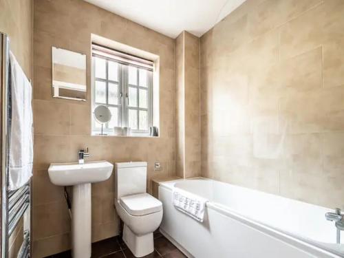 Spacious modern home in picturesque village في إكسيتير: حمام مع مرحاض وحوض استحمام ومغسلة