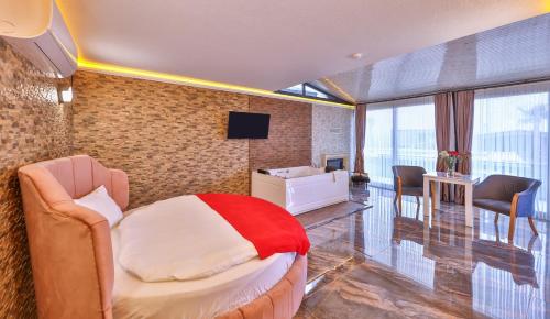 a bedroom with a bed and a desk and a television at Agva Teras Garden Hotel & Bungalow in Agva