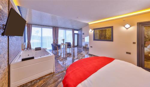 a bedroom with a bed and a tub and a sink at Agva Teras Garden Hotel & Bungalow in Agva