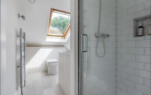a bathroom with a shower and a toilet and a window at Gorgeous 1 bedroom & private ensuite in Central Windsor home with FREE PARKING in Windsor