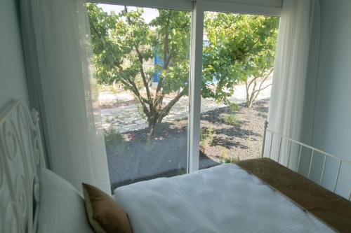 a bedroom with a bed and a large window at Gadura Kır Evleri Urla in Urla