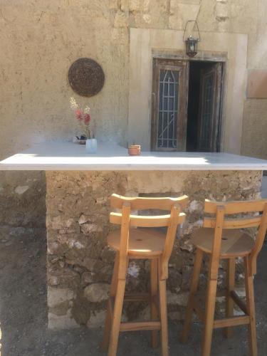 two chairs sitting at a counter in front of a stone building at Tanirt ecolodge in Siwa
