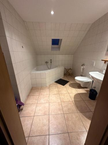La salle de bains est pourvue d'une baignoire et de toilettes. dans l'établissement Apartment Emilia, à Leipzig