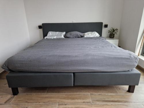 a bed in a bedroom with a gray blanket on it at Volledige gezinswoning te huur in Mechelen