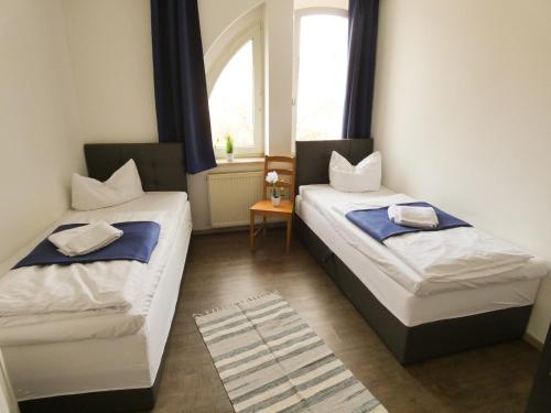 魏登的住宿－SUNNYHOME Monteurwohnungen und Apartments in Weiden，两张睡床彼此相邻,位于一个房间里