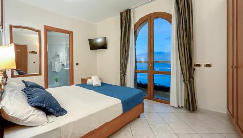 HR Hotel & Spa في بيانو دي سورينتو: غرفة نوم مع سرير وإطلالة على المحيط