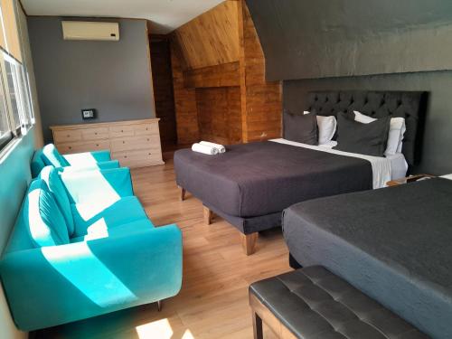 サンティアゴにあるHotel Sonettoのベッド2台とソファが備わるホテルルームです。