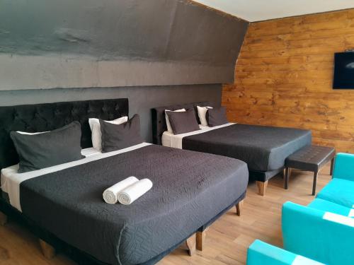 2 Betten in einem Zimmer mit blauen Stühlen in der Unterkunft Hotel Sonetto in Santiago