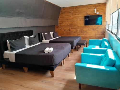 a bedroom with two beds and a couch and a tv at Hotel Sonetto in Santiago