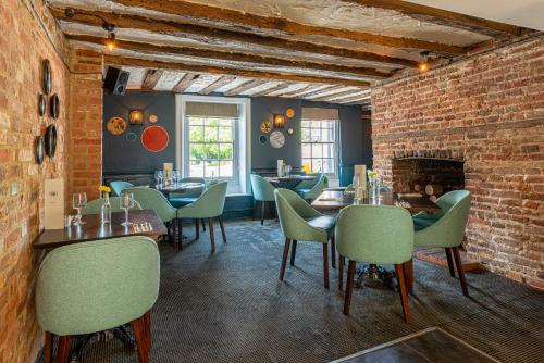 a restaurant with tables and chairs and a brick wall at The Ship Hotel in New Romney