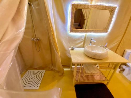 a bathroom with a sink and a mirror and a shower at Merzouga Heart Luxury Camp in Merzouga