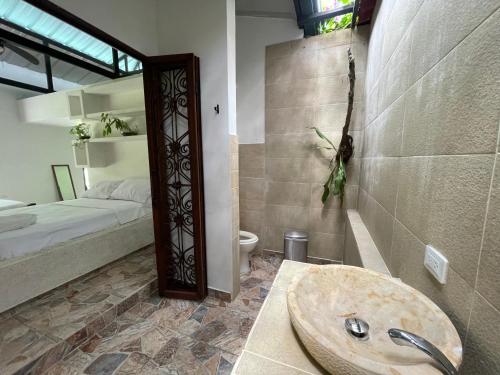 łazienka z umywalką oraz sypialnia z łóżkiem w obiekcie Catleya Cabaña Campestre w mieście Villavicencio