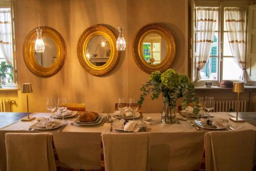 una sala da pranzo con tavolo e piatti di cibo e specchi di Locanda Sant' Agostino a Lucca