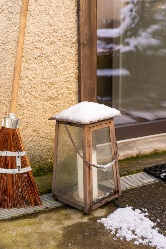 a snow covered lantern sitting next to a broom at Tiny House Chez Claudine - Relaxen, Workspace, Nähe Thermen, Netflix, free Parking & Wifi in Brugg