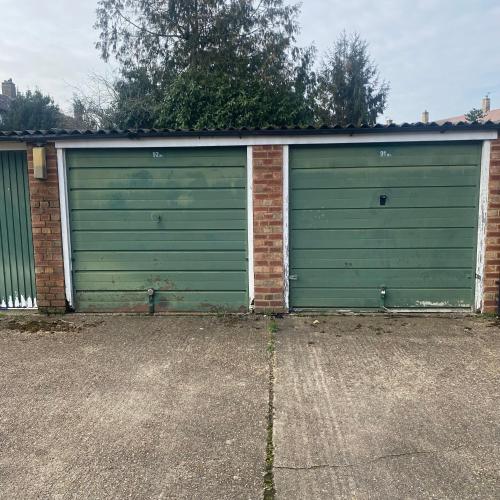 un par de puertas de garaje en una casa en Garage for rent as storage or keep your car, none suitable for living en Stanwell