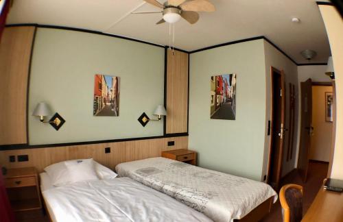 a bedroom with a bed and pictures on the wall at Hotel Seebach in Großenseebach