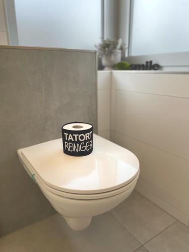 a toilet with a sticker on the lid of it at Femo SCHICK-modern, Natur, Rothaarsteig, 2Etg, 2Bäder in Burbach