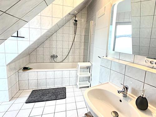 a white bathroom with a tub and a sink at Femo SCHICK-modern, Natur, Rothaarsteig, 2Etg, 2Bäder in Burbach