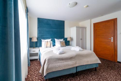 a bedroom with a large bed with towels on it at Hotel Azzun Orient SPA&Wellness in Kromerowo