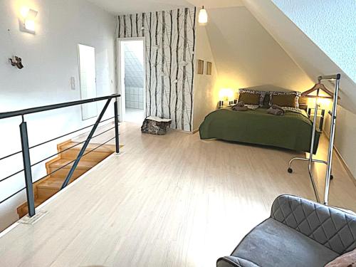 een slaapkamer met een groen bed en een bank bij Femo SCHICK-modern, Natur, Rothaarsteig, 2Etg, 2Bäder in Burbach