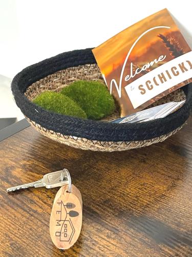 a basket with a keychain next to a bowl with a book at Femo SCHICK-modern, Natur, Rothaarsteig, 2Etg, 2Bäder in Burbach