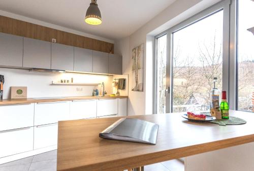 a kitchen with white cabinets and a large window at Femo SCHICK-modern, Natur, Rothaarsteig, 2Etg, 2Bäder in Burbach