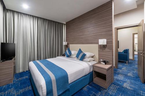 a hotel room with a bed and a television at Best Western Plus Tabuk City Center in Tabuk