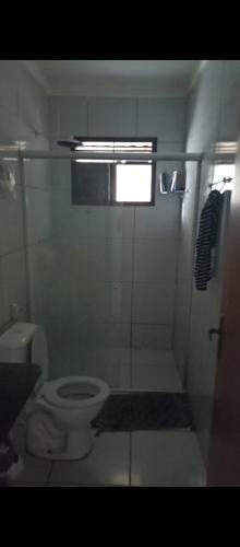 a bathroom with a toilet and a shower with a window at Casa em Cajupiranga temporada in Parnamirim