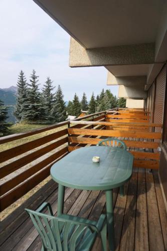 une table bleue et des chaises sur une terrasse en bois dans l'établissement Résidence Horizon 1800 I - 3 pièces 6 personnes MAE-9954, à Orcières