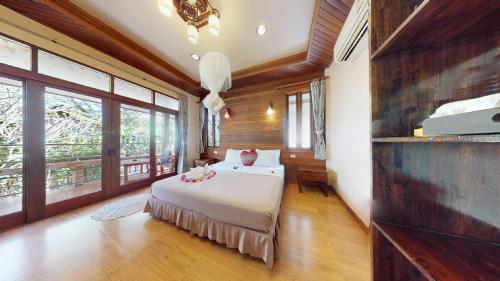 a bedroom with a bed in a room with windows at Pen's Bungalow Koh Phangan in Thong Nai Pan Yai