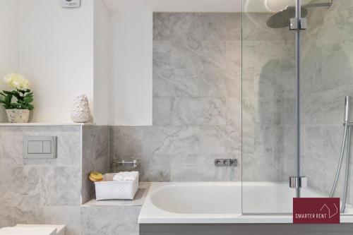 a bathroom with a tub and a glass shower at 3 Bedroom Apartment - Kew Village in Richmond upon Thames