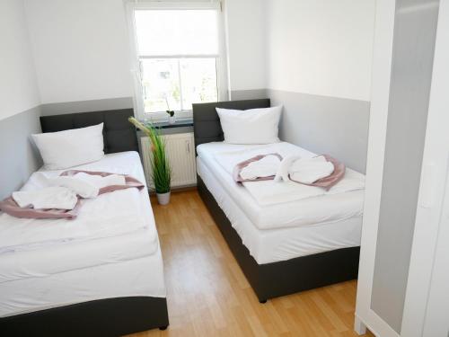 Dos camas en una habitación con toallas. en SUNNYHOME Monteurwohnungen und Apartments in Weiden en Weiden