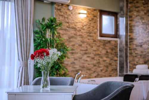 a vase of red and white flowers on a table at Agva Teras Garden Hotel & Bungalow in Agva