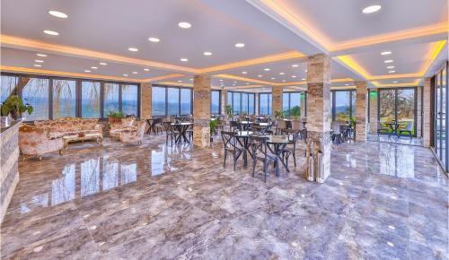 a large room with tables and chairs and windows at Agva Teras Garden Hotel & Bungalow in Agva
