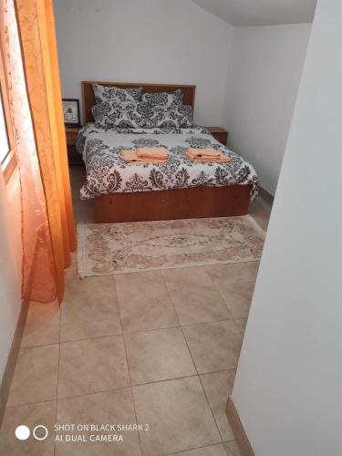 a bedroom with a bed and a tiled floor at Casa Gheorghe in Balabancea