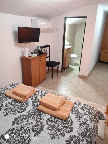 1 dormitorio con cama, escritorio y espejo en Casa Gheorghe, en Balabancea