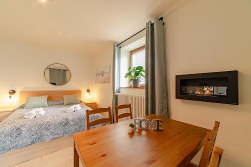 ein Schlafzimmer mit einem Bett und einem Tisch sowie ein Esszimmer in der Unterkunft Casa Galya with private patio by GardaDoma in Brenzone sul Garda