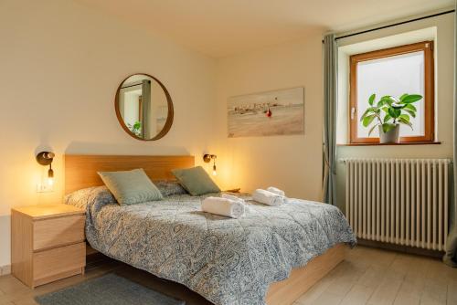 a bedroom with a bed and a mirror and a window at Casa Galya with private patio by GardaDoma in Brenzone sul Garda
