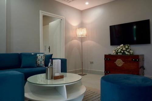 a living room with a blue couch and a table at Suites Hôtel Les Charmilles & Spa in La Marsa