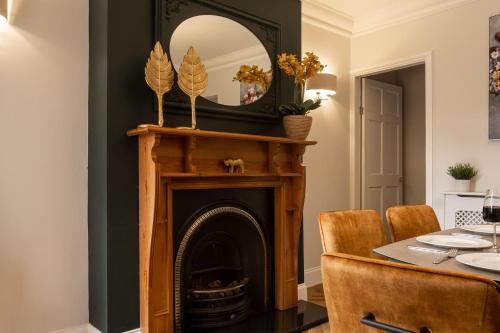 a dining room with a fireplace and a mirror at Ellistown Retreat in Hugglescote