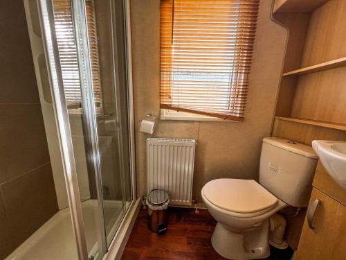 a small bathroom with a toilet and a shower at Lovely Caravan At Manor Park, Nearby Hunstanton Beach In Norfolk Ref 23067s in Hunstanton