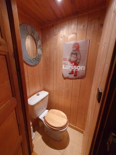 La salle de bains est pourvue de toilettes et d'une affiche murale. dans l'établissement Chalet l Abondance, à La Chapelle-dʼAbondance