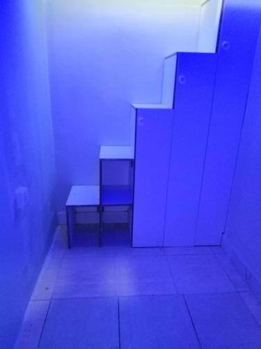 a room with two benches in a room with blue lights at Partition available 2 minutes away from Rigga metro Asians Only in Dubai
