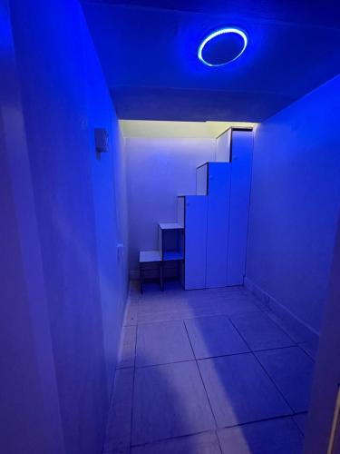a dark room with a blue light and stairs at Partition available 2 minutes away from Rigga metro Asians Only in Dubai