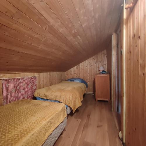 - 2 lits dans une petite chambre avec des murs en bois dans l'établissement Chalet l Abondance, à La Chapelle-dʼAbondance