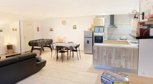 a kitchen and a living room with a table and chairs at Chalet en pleine nature Pomerol in Pomerol