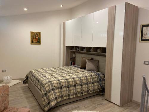 een slaapkamer met een bed met een geruite deken bij Casa del pittore in Niscemi