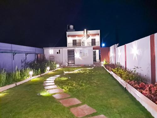 a house with a yard at night with lights at Private Paradise Opposite Nandi Hills in Bangalore
