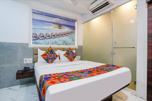 a bedroom with a bed with a colorful blanket at FabExpress Ashoka Inn - Nr Mumbai International Airport in Mumbai