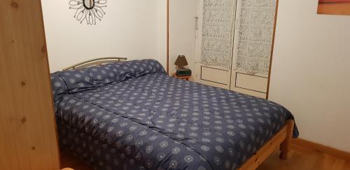 Bett mit blauer Decke in einem Zimmer in der Unterkunft T2 Luchon Centre 5 nuits minimum in Luchon